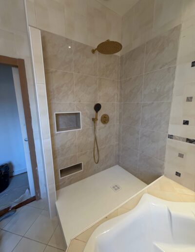 Rénovation de salle de bains avec douche sur mesure Douche à l’italienne rénovée avec niches murales et carrelage moderne
